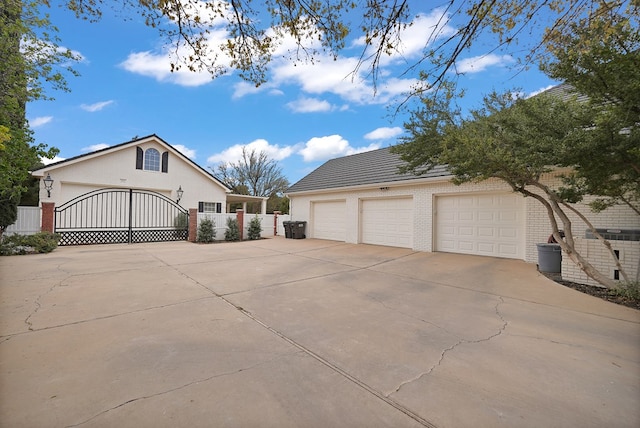 view of side of home with an outdoor structure, brick siding, a gate, and fence