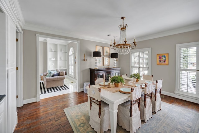 dining area featuring ornamental molding, a notable chandelier, baseboards, and wood finished floors
