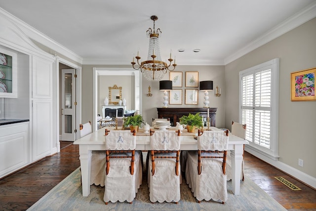 dining area with an inviting chandelier, dark wood-style floors, crown molding, and visible vents