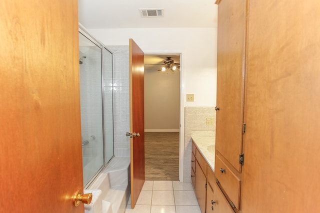 bathroom with tile patterned flooring, vanity, ceiling fan, and bath / shower combo with glass door