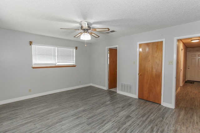 spare room featuring a textured ceiling, ceiling fan, and dark hardwood / wood-style floors