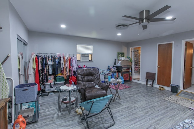 living room with ceiling fan, cooling unit, and wood-type flooring