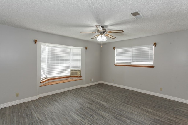 empty room with a textured ceiling, ceiling fan, cooling unit, and dark hardwood / wood-style floors