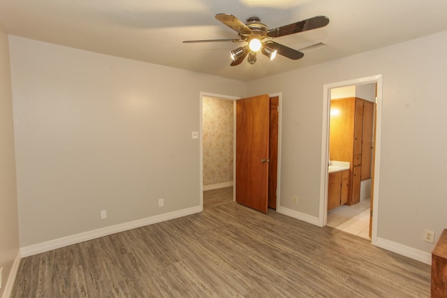 unfurnished bedroom featuring connected bathroom, light hardwood / wood-style flooring, and ceiling fan