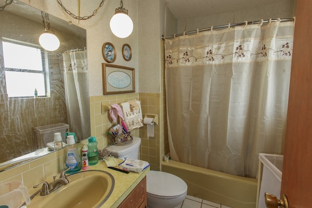 full bathroom with tile patterned flooring, toilet, shower / bath combo with shower curtain, and tile walls