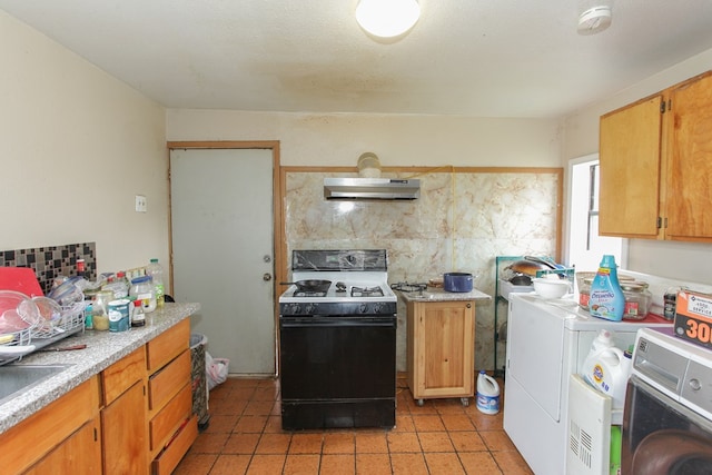 kitchen featuring separate washer and dryer, light tile patterned floors, extractor fan, and black electric range