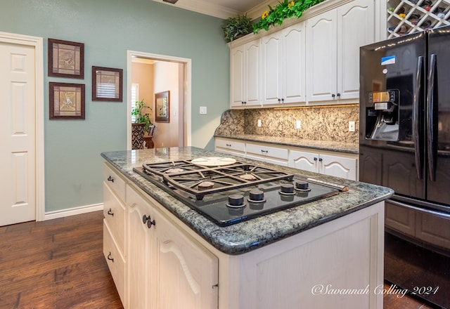 kitchen featuring dark wood-type flooring, black appliances, crown molding, decorative backsplash, and a kitchen island