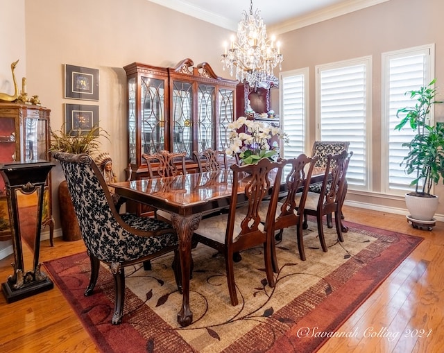 dining space featuring light hardwood / wood-style flooring, a chandelier, and ornamental molding