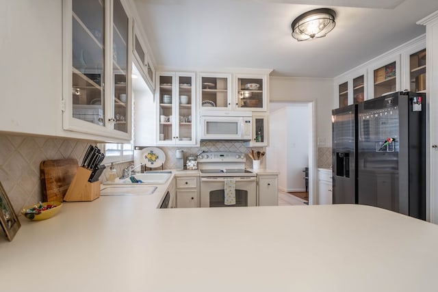 2209 Shell Ave, Midland, TX 79705 - kitchen with white appliances, a sink, decorative backsplash, light countertops, and ornamental molding