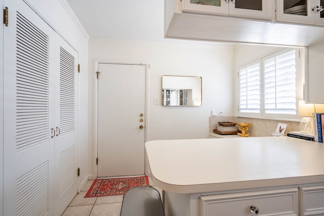 2209 Shell Ave, Midland, TX 79705 - kitchen with light countertops, crown molding, glass insert cabinets, tasteful backsplash, and light tile patterned floors