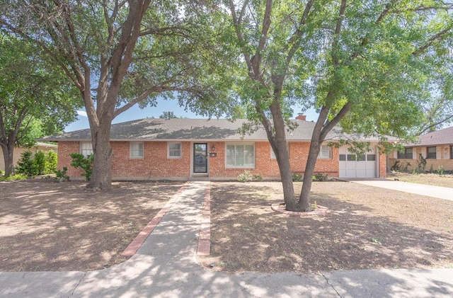 2209 Shell Ave, Midland, TX 79705 - ranch-style home featuring brick siding, concrete driveway, a garage, and a chimney