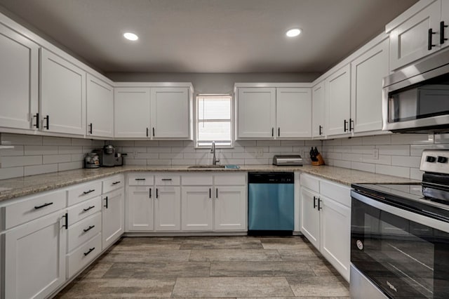 4003 Angelina Dr, Midland, TX 79705 - kitchen featuring appliances with stainless steel finishes, a sink, white cabinetry, recessed lighting, and tasteful backsplash