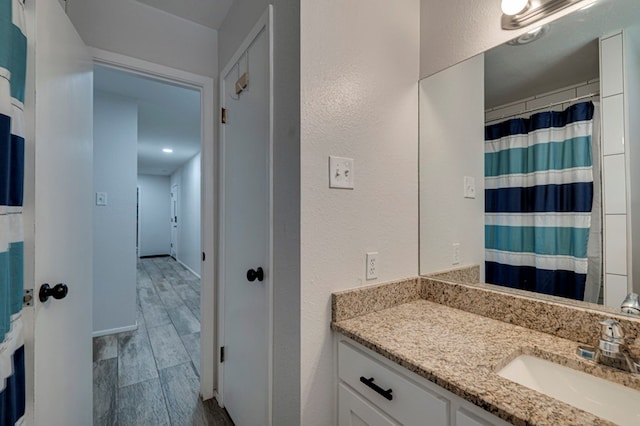 4003 Angelina Dr, Midland, TX 79705 - bathroom with vanity, wood tiled floors, and a textured wall