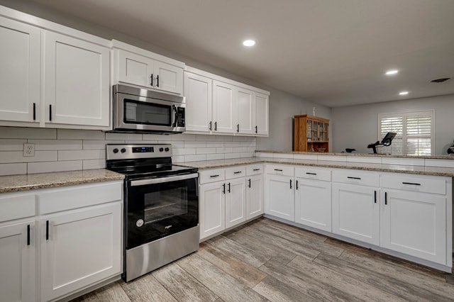 4003 Angelina Dr, Midland, TX 79705 - kitchen with stainless steel appliances, recessed lighting, white cabinets, light wood-style flooring, and backsplash