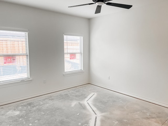 spare room with ceiling fan and unfinished concrete floors