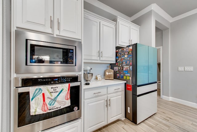 13 La Cresta Ave, Odessa, TX 79765 - kitchen with stainless steel appliances, white cabinets, decorative backsplash, light countertops, and baseboards