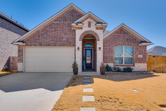 view of front of house with concrete driveway, fence, stone siding, brick siding, and a garage