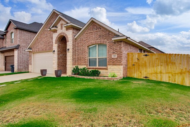 13 La Cresta Ave, Odessa, TX 79765 - view of front of home featuring brick siding, concrete driveway, a garage, and a shingled roof