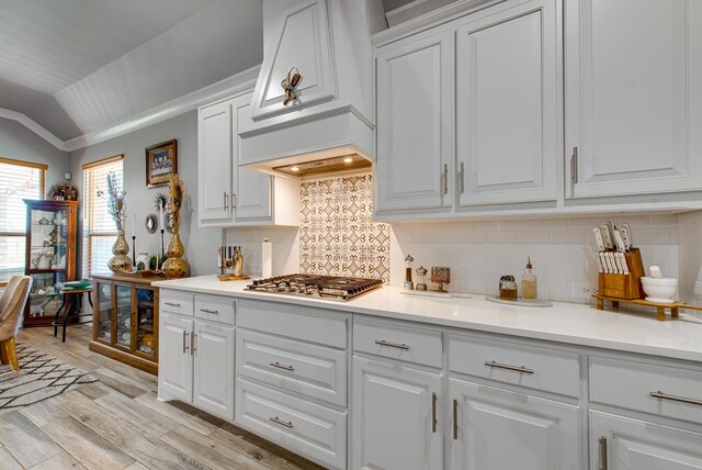 13 La Cresta Ave, Odessa, TX 79765 - kitchen featuring stainless steel gas cooktop, lofted ceiling, white cabinetry, ornamental molding, and light countertops