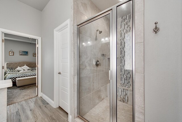 bathroom with baseboards, a stall shower, ensuite bath, and wood finished floors