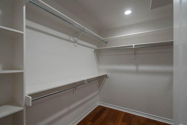 walk in closet with dark hardwood / wood-style flooring