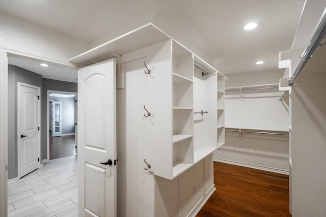 walk in closet with light hardwood / wood-style flooring