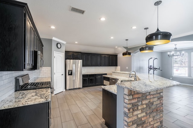 kitchen with sink, a large island, appliances with stainless steel finishes, and decorative light fixtures