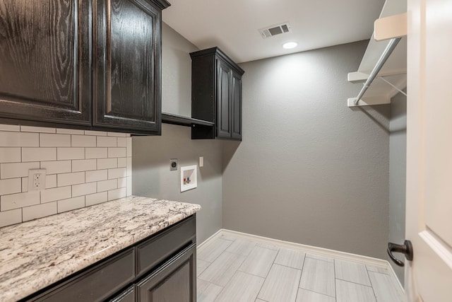 laundry area with cabinet space, baseboards, hookup for an electric dryer, and hookup for a washing machine
