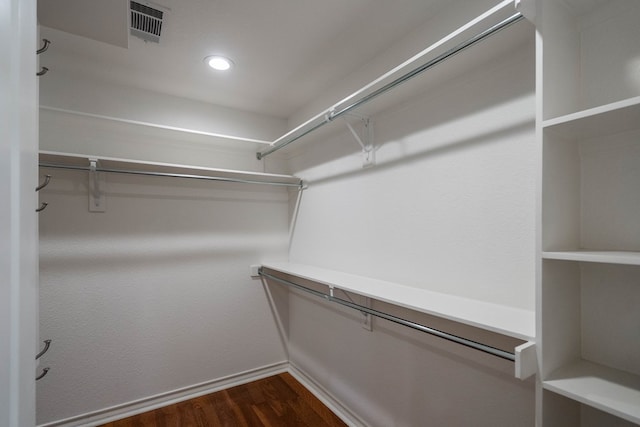 walk in closet with dark wood-type flooring