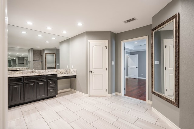 bathroom featuring recessed lighting, baseboards, and vanity
