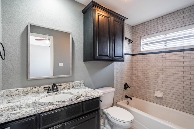 bathroom featuring vanity, toilet, shower / washtub combination, and a textured wall