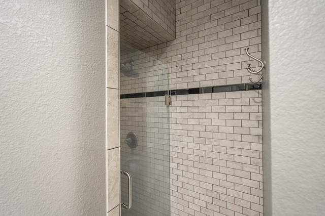 bathroom view of a textured wall and a stall shower