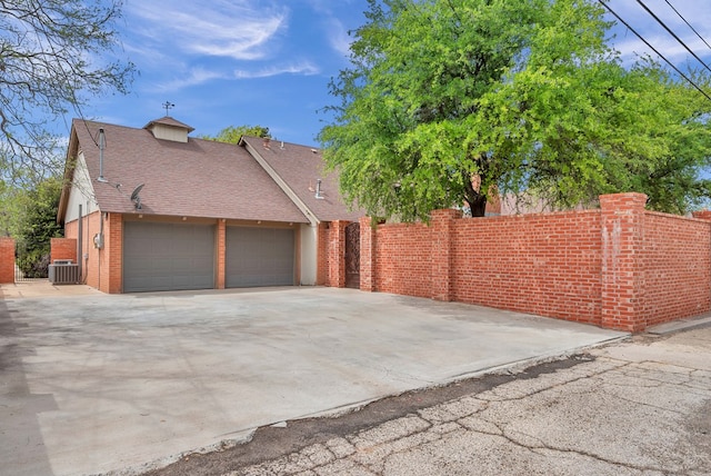 view of property exterior with a garage and central air condition unit