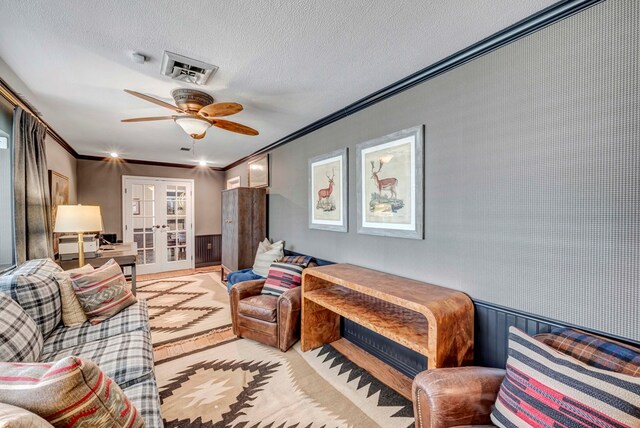 living room featuring french doors, a textured ceiling, ceiling fan, and ornamental molding