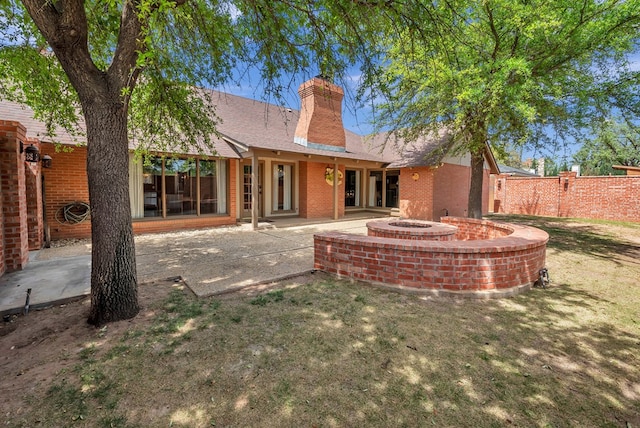 back of house with a yard and a patio