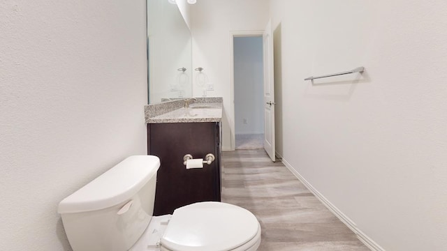 bathroom with vanity, wood-type flooring, and toilet