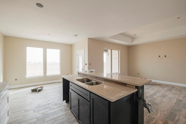2201 S County Rd 1059, Midland, TX 79706 - kitchen with open floor plan, light wood-style flooring, dark cabinetry, and baseboards