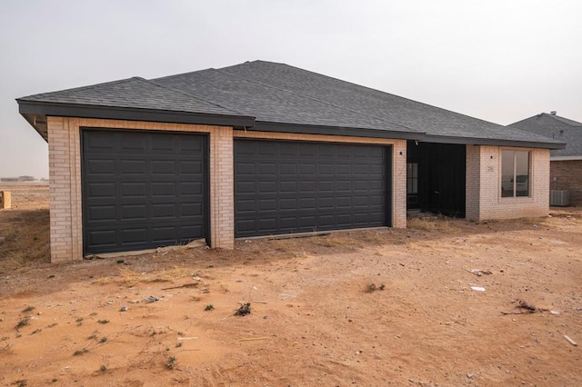 garage featuring central air condition unit and driveway