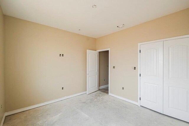 2201 S County Rd 1059, Midland, TX 79706 - unfurnished bedroom featuring a closet, baseboards, and concrete flooring