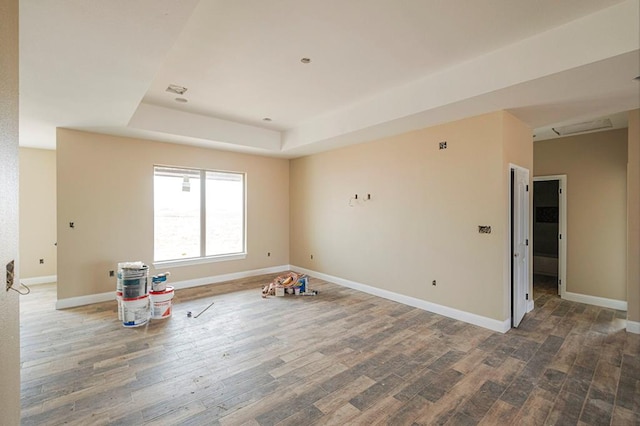 2201 S County Rd 1059, Midland, TX 79706 - unfurnished room with baseboards, a tray ceiling, and wood finished floors