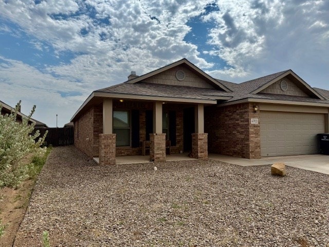 6712 Spur Dr, Midland, TX 79705 - view of front of house with a porch, a garage, concrete driveway, and brick siding