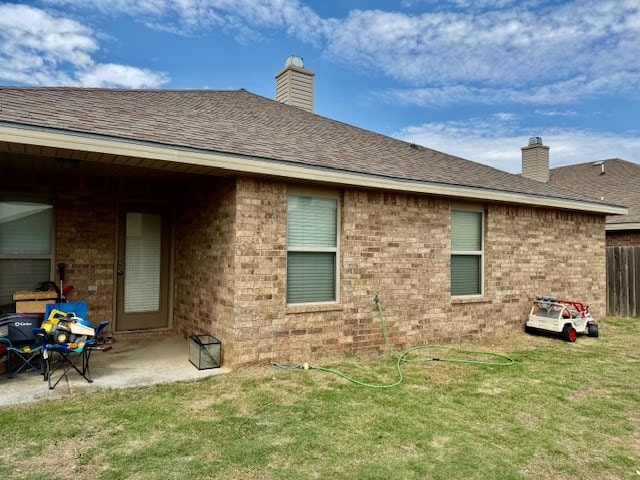 6712 Spur Dr, Midland, TX 79705 - back of house featuring brick siding, a chimney, a patio area, and a shingled roof