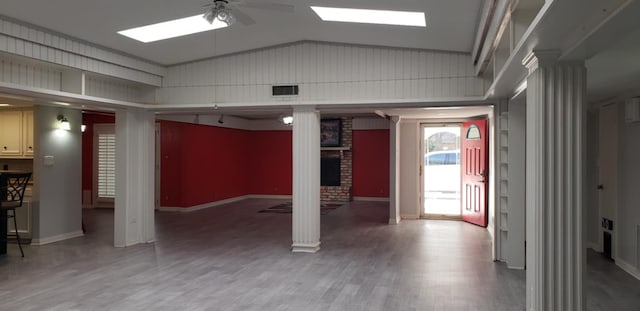 interior space featuring hardwood / wood-style flooring, vaulted ceiling, ceiling fan, and ornate columns