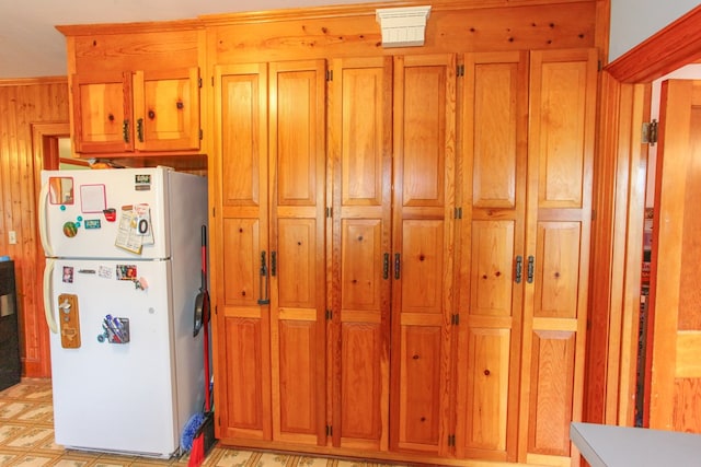 4610 Wasson Rd, Big Spring, TX 79720 - kitchen featuring freestanding refrigerator, brown cabinetry, and wooden walls