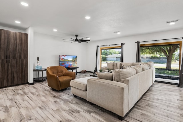 living room featuring ceiling fan and light hardwood / wood-style flooring