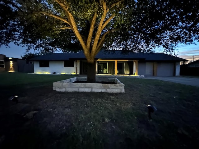 view of front of property with a garage and a yard