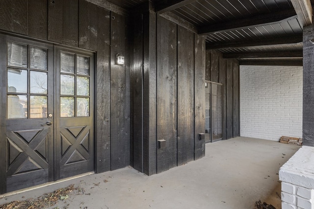 interior space featuring wood walls, concrete flooring, and brick wall