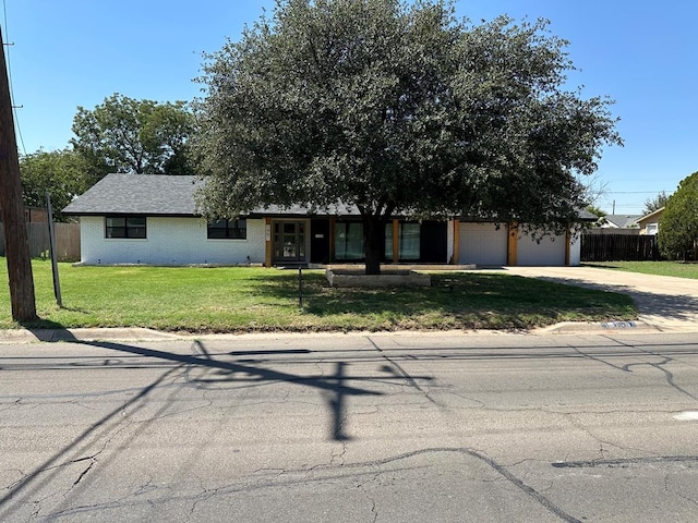 view of front of home with a garage and a front lawn