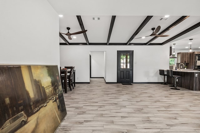 living room with beamed ceiling, ceiling fan, and light hardwood / wood-style flooring