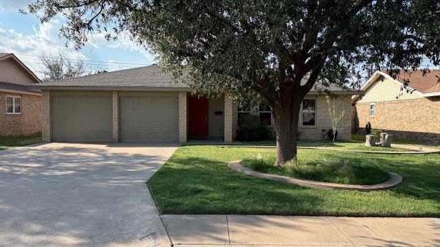3704 W Michigan Ave, Midland, TX 79703 - view of front facade featuring brick siding, driveway, a front yard, and a garage